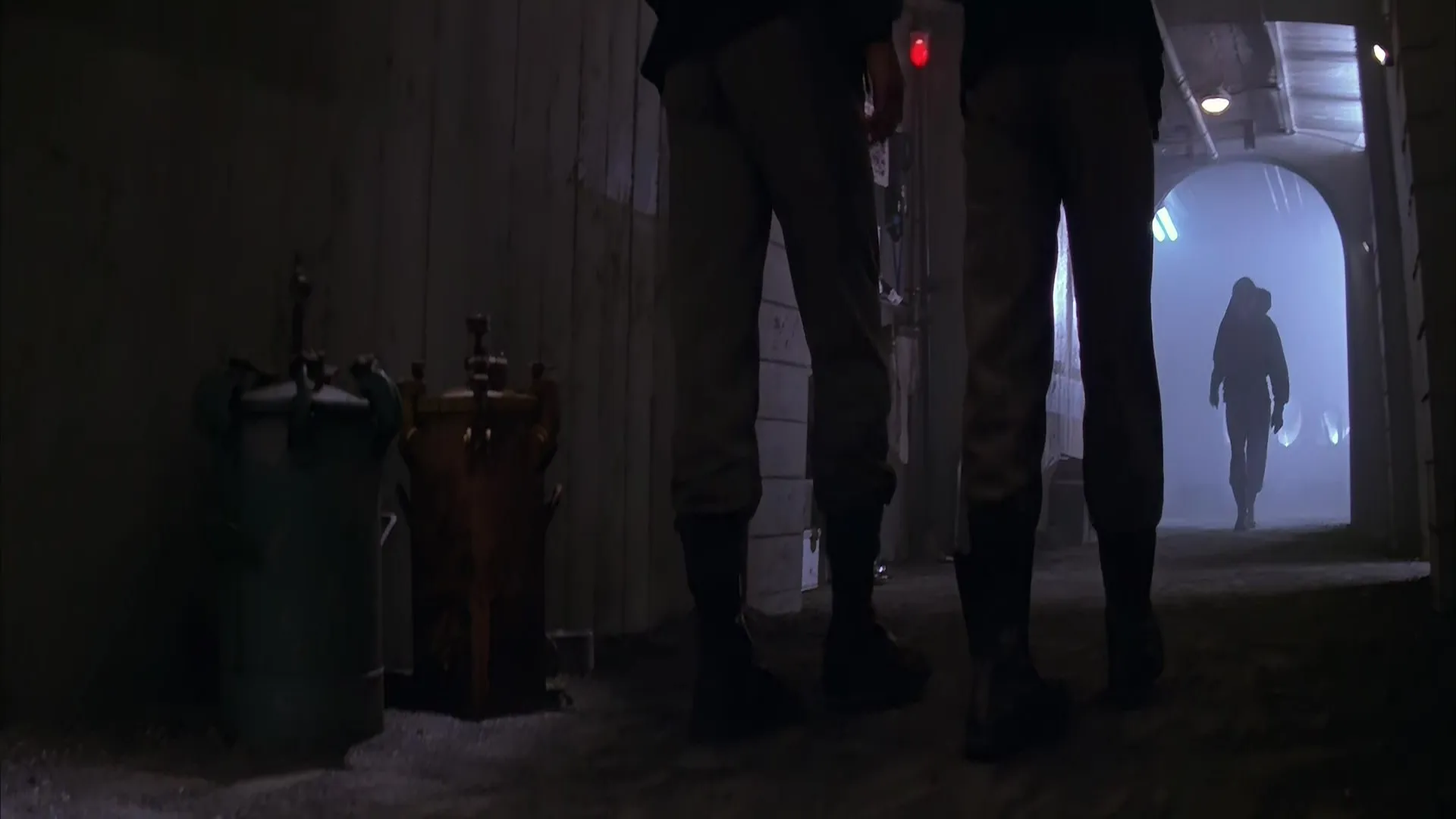 Prisoners walk through the dim, industrial corridors of Fiorina 161, lit by harsh lamps and shadows