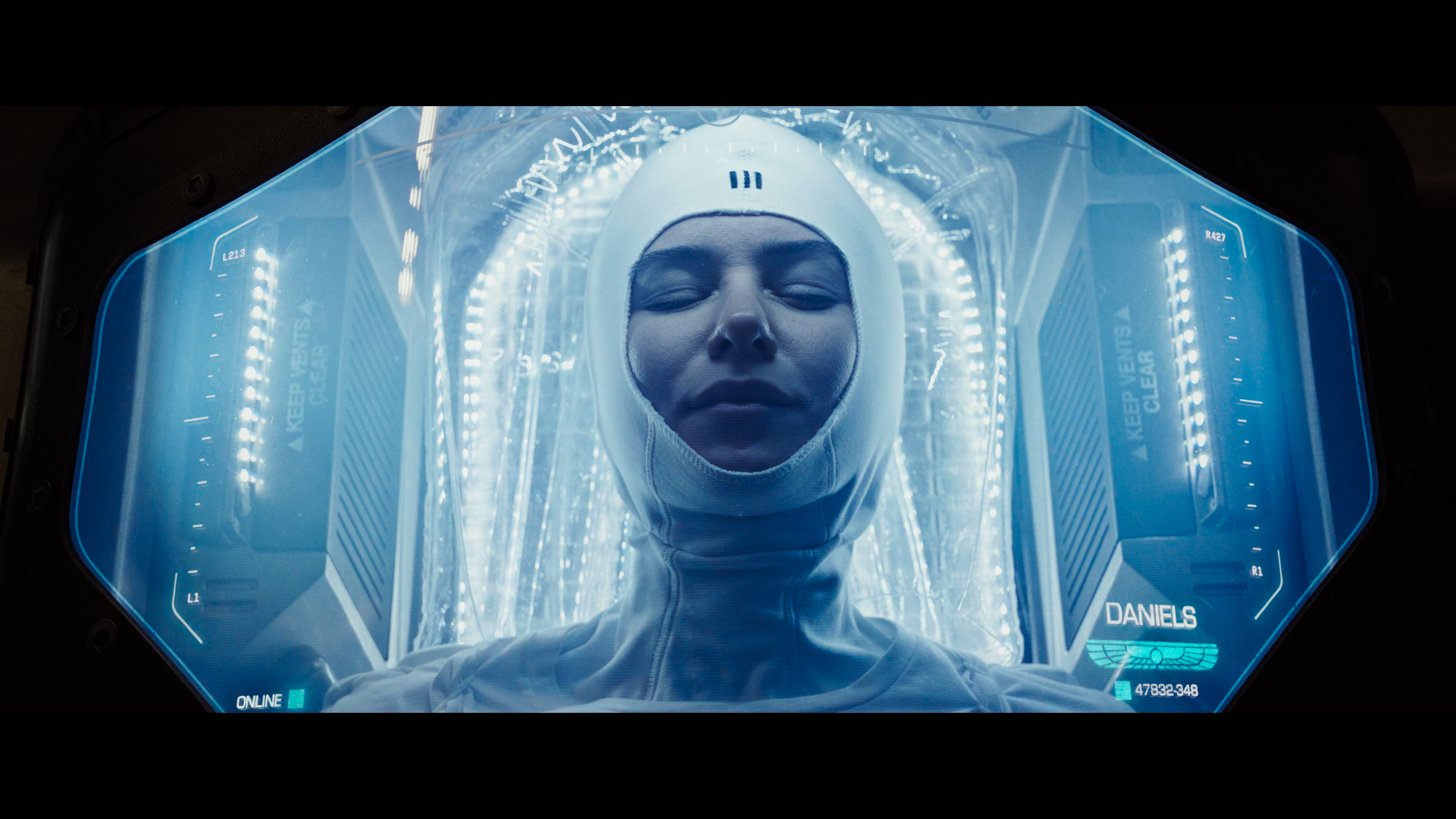 Daniels lies in her cryosleep pod, serene under glowing blue light