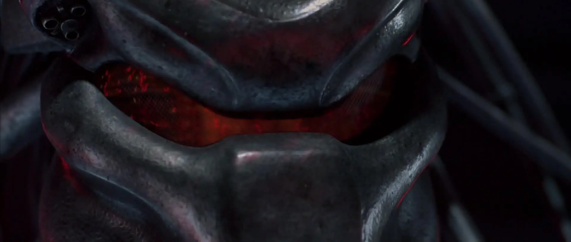 Close-up of a Predator mask lit from within.