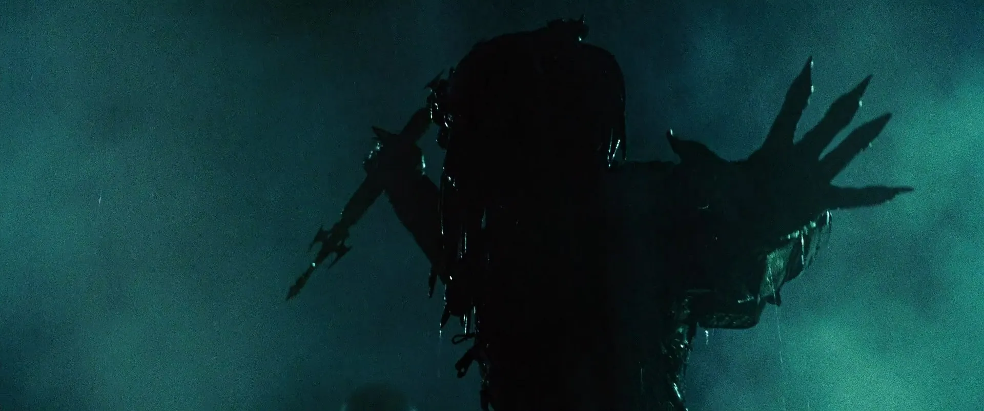 The veteran Predator Wolf stands in rain, extending a combi‑stick for the hunt