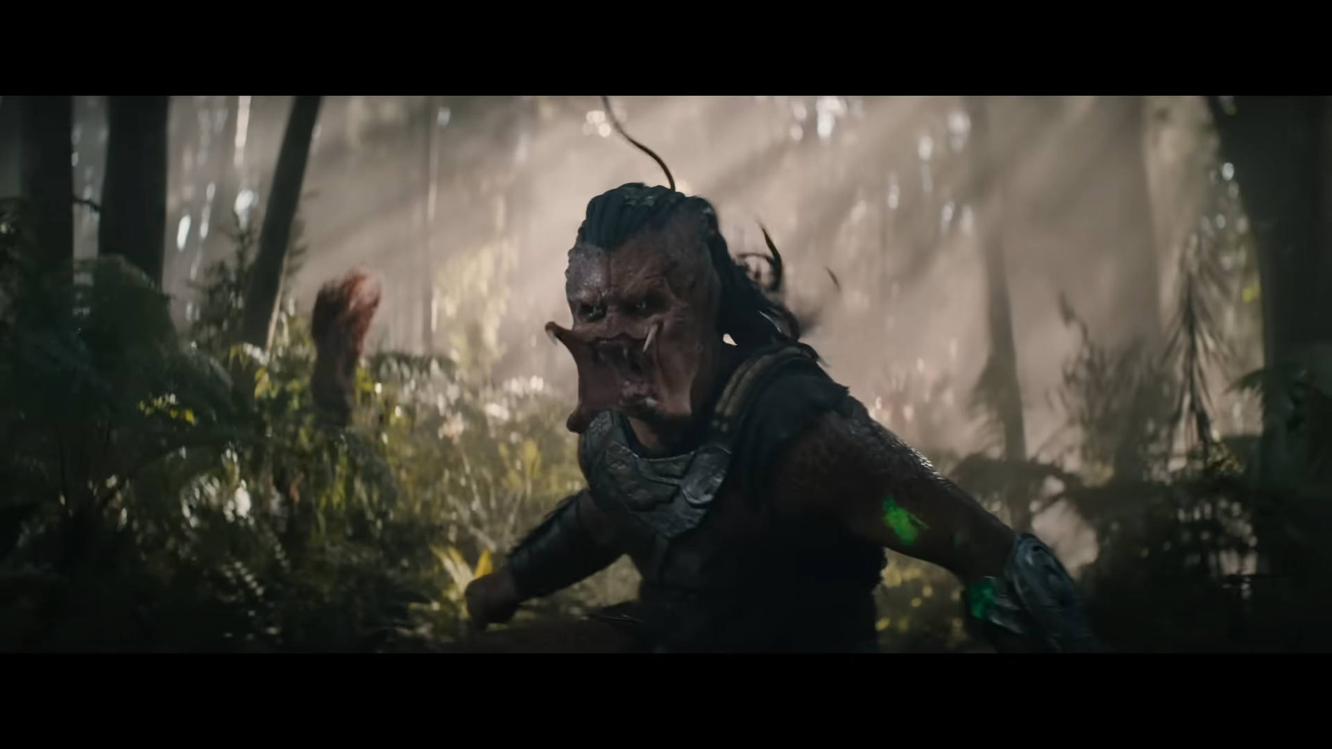 Close view of the Yautja sprinting through shafts of light in dense jungle