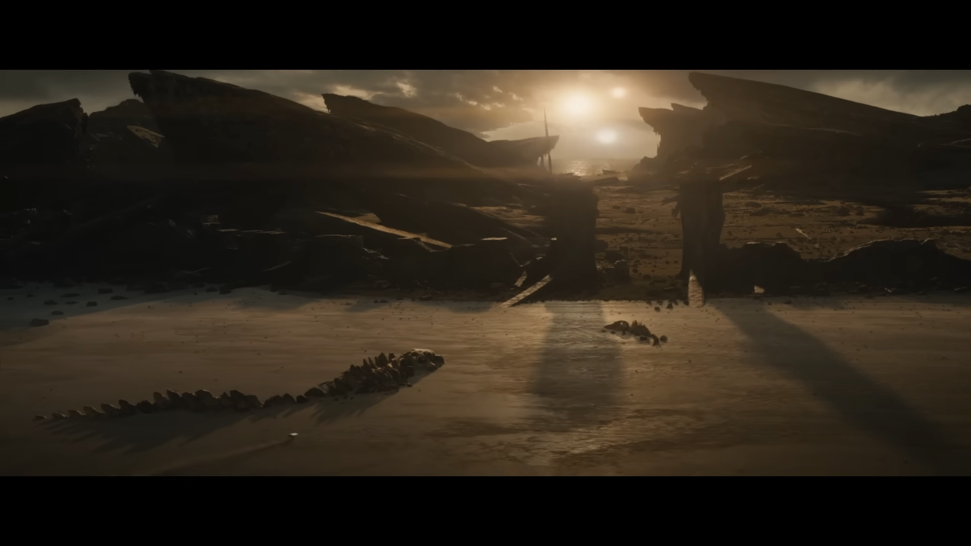 Twin suns burn above a desolate coastline strewn with titanic bones